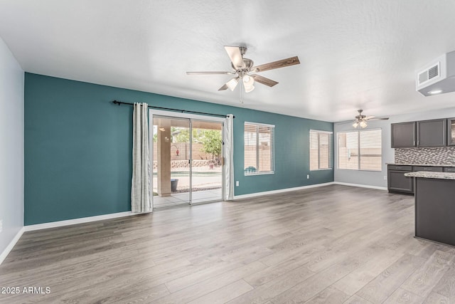 10440 E Osage Ave, Mesa, AZ 85212 - unfurnished living room featuring a ceiling fan, baseboards, and light wood-style flooring