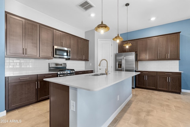 kitchen featuring an island with sink, stainless steel appliances, sink, and dark brown cabinets