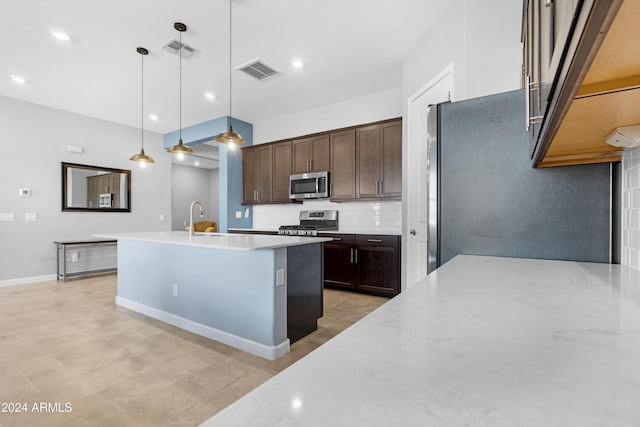 kitchen with pendant lighting, appliances with stainless steel finishes, backsplash, light stone counters, and dark brown cabinetry