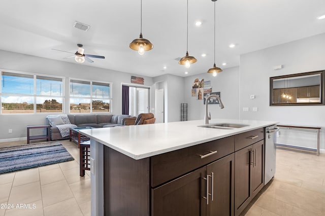 kitchen featuring pendant lighting, dishwasher, sink, ceiling fan, and a center island with sink