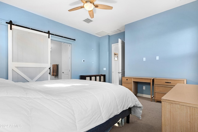 bedroom featuring ceiling fan, a barn door, and light carpet