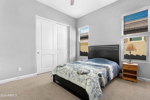 bedroom with light carpet, a closet, and ceiling fan