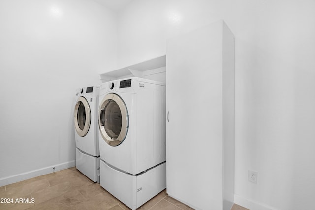 laundry room featuring light tile patterned floors and washing machine and dryer