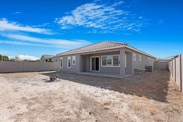 back of house with central AC unit, a fire pit, and a patio area