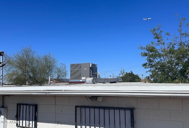 exterior details featuring cooling unit and concrete block siding