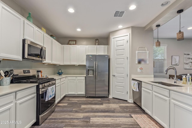 16750 W Evergreen Rd, Waddell, AZ 85355 - kitchen with stainless steel appliances, a sink, white cabinets, dark wood finished floors, and recessed lighting