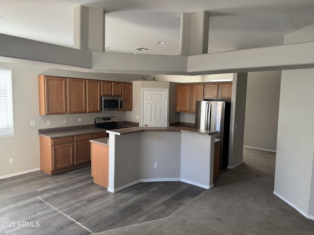 kitchen with appliances with stainless steel finishes, a center island, and wood-type flooring