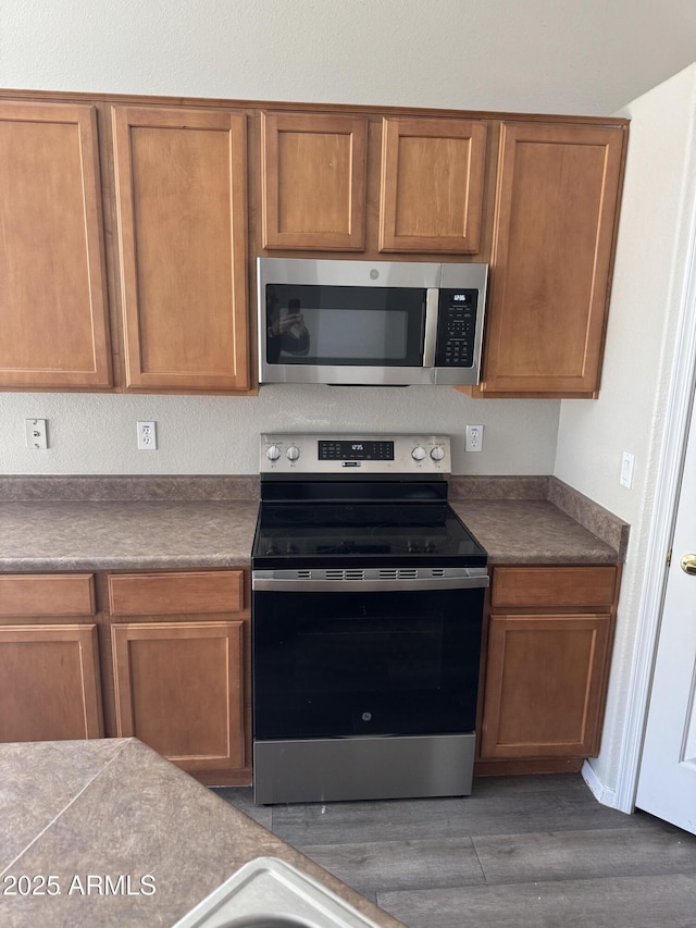 kitchen with dark hardwood / wood-style floors and appliances with stainless steel finishes