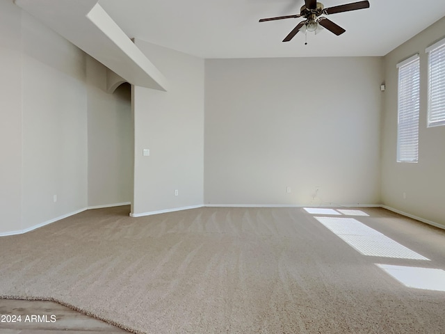 spare room featuring ceiling fan and light colored carpet