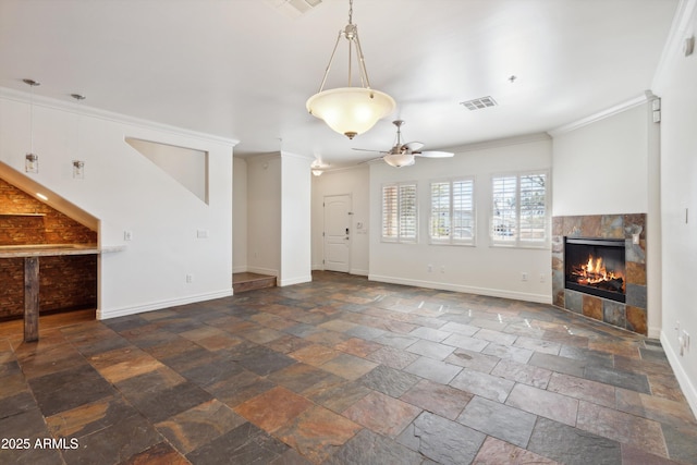 unfurnished living room featuring ceiling fan, ornamental molding, and a tiled fireplace