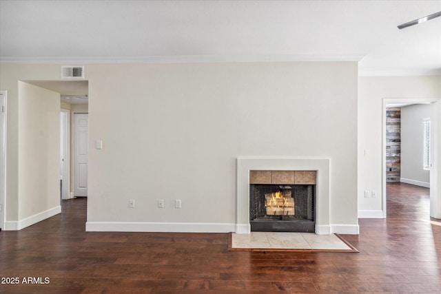 unfurnished living room with dark hardwood / wood-style flooring, ornamental molding, and a fireplace