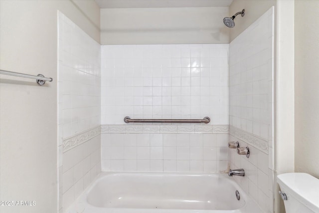 bathroom with tiled shower / bath combo and toilet