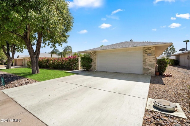 single story home featuring a garage and a front lawn