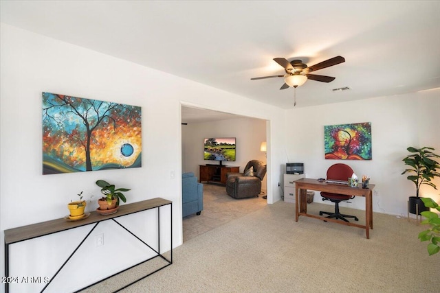 home office with light carpet and ceiling fan