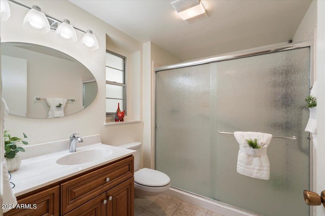 bathroom featuring vanity, toilet, an enclosed shower, and tile patterned floors