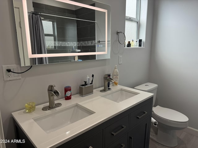 bathroom with a shower with curtain, hardwood / wood-style floors, vanity, and toilet