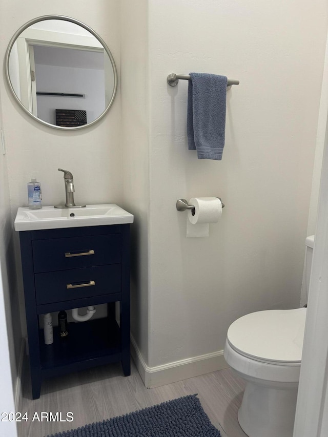 bathroom featuring hardwood / wood-style flooring, vanity, and toilet