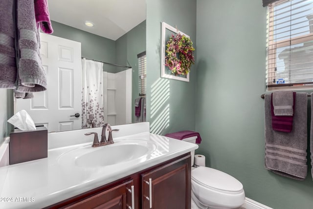 bathroom with toilet, vanity, and a shower with shower curtain