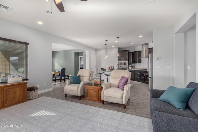 living room featuring ceiling fan and light wood-type flooring