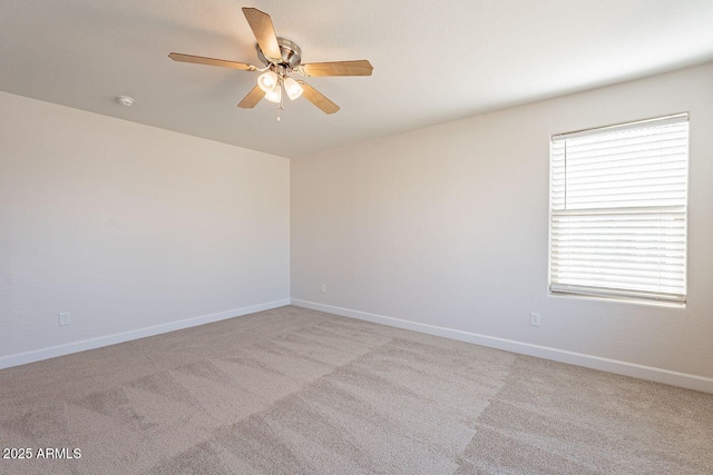 unfurnished room featuring baseboards, light carpet, and a ceiling fan