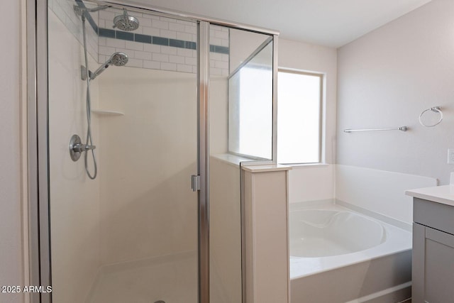 full bath featuring vanity, a shower stall, and a garden tub