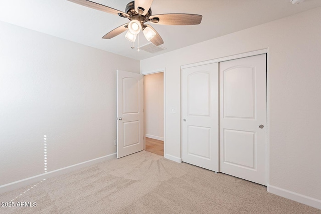 unfurnished bedroom featuring carpet, baseboards, a closet, and ceiling fan