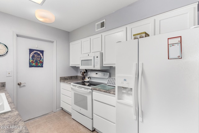 kitchen featuring white appliances, white cabinets, and light tile patterned flooring