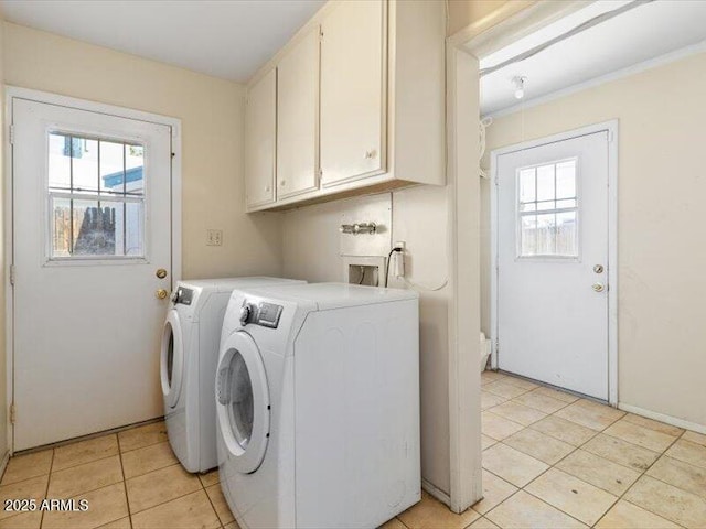 laundry room with a wealth of natural light, washer and dryer, cabinet space, and light tile patterned floors