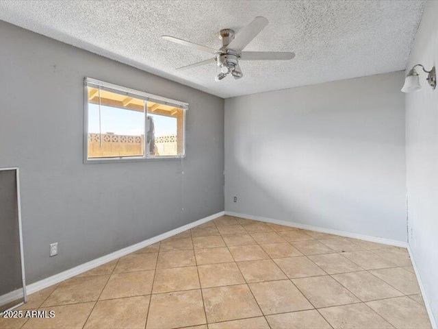 unfurnished room featuring ceiling fan, baseboards, a textured ceiling, and light tile patterned flooring