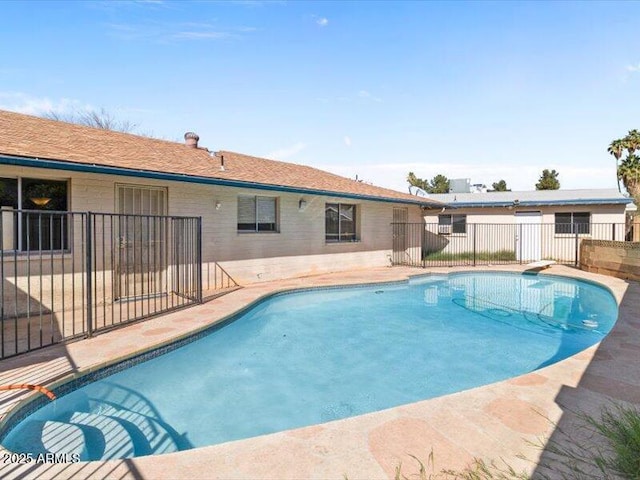 outdoor pool featuring fence and a patio