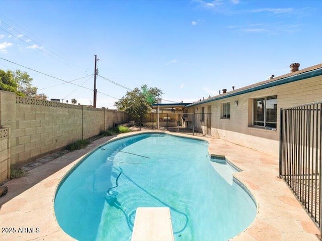 view of swimming pool with a patio area, a fenced backyard, a diving board, and a fenced in pool