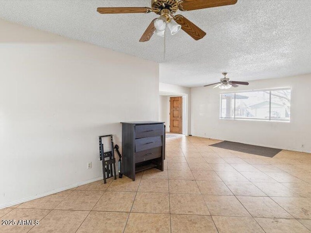 unfurnished room with a textured ceiling and light tile patterned flooring