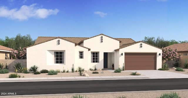 view of front of house with driveway, fence, an attached garage, and stucco siding