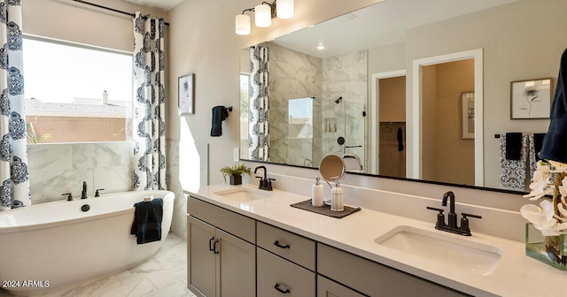 full bathroom featuring a freestanding tub, marble finish floor, a sink, and a shower stall