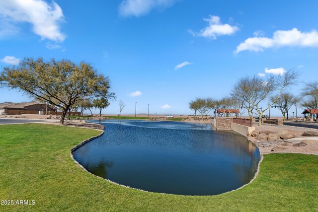 view of swimming pool with a water view and a lawn