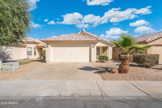 view of front of home with an attached garage, a tiled roof, concrete driveway, and stucco siding