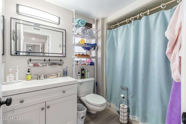 bathroom with walk in shower, vanity, toilet, and hardwood / wood-style floors