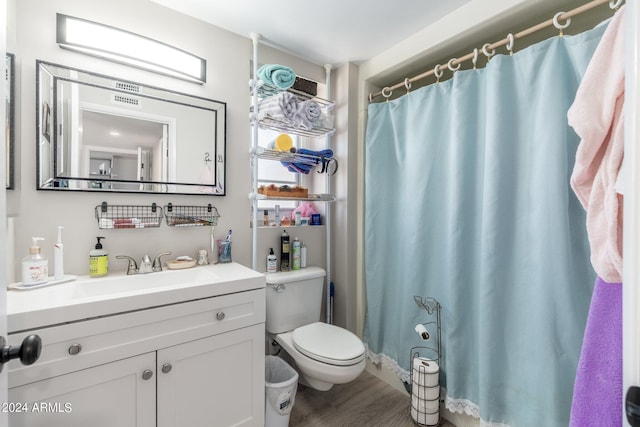 bathroom featuring toilet, vanity, a shower with curtain, and wood finished floors