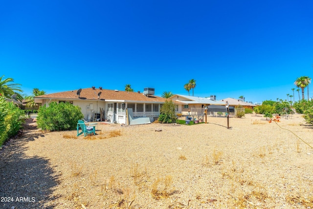 rear view of property featuring cooling unit and a sunroom