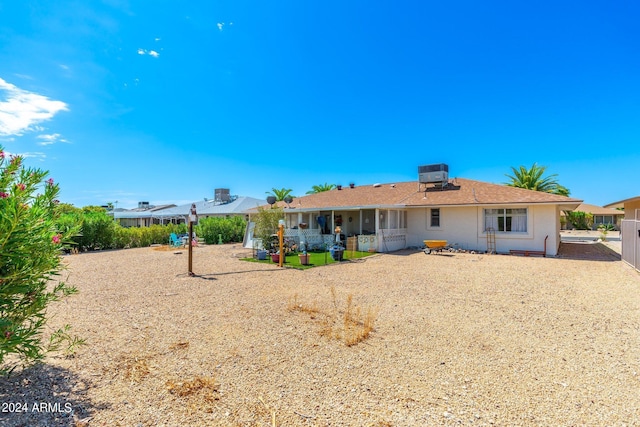 rear view of property with cooling unit and fence