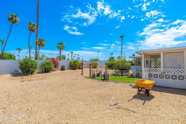 view of yard featuring fence and a sunroom