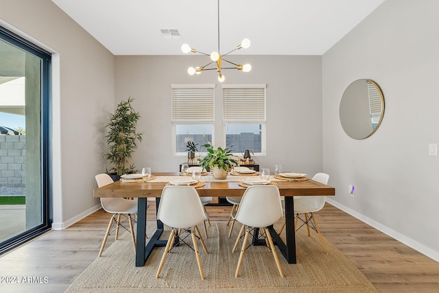 dining room with a notable chandelier and light wood-type flooring