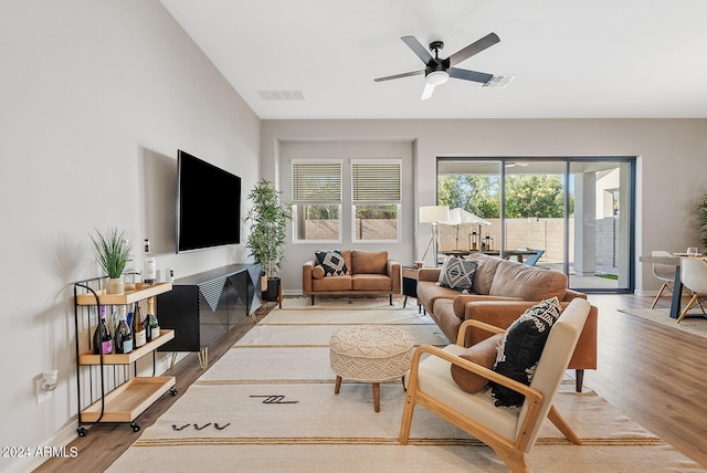 living room with a wealth of natural light, wood-type flooring, and ceiling fan