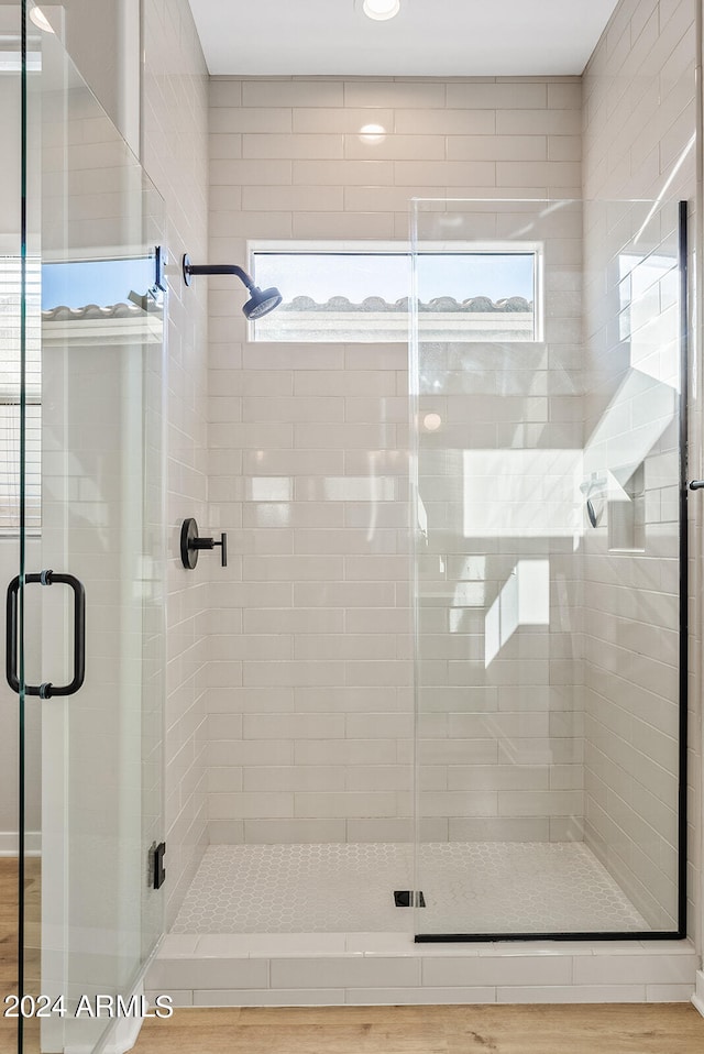 bathroom featuring wood-type flooring and a shower with door