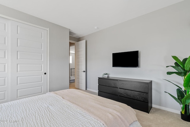 bedroom with light colored carpet and a closet