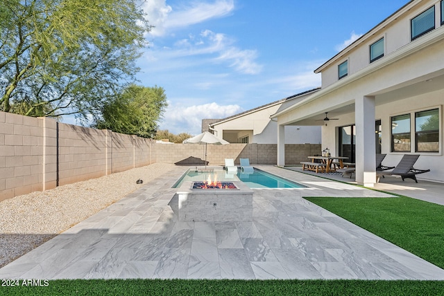 view of pool featuring ceiling fan, a patio area, and an outdoor fire pit