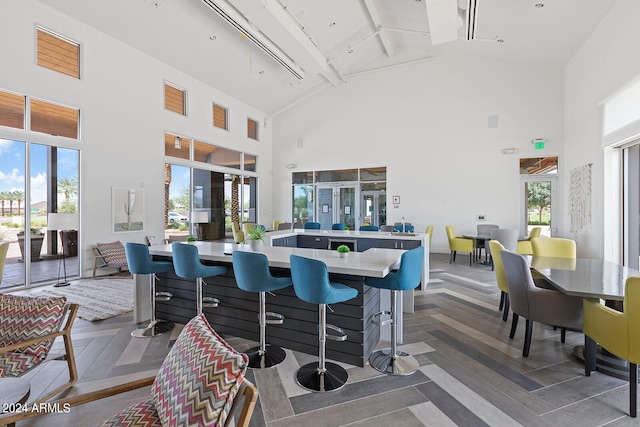 dining area featuring high vaulted ceiling, a wealth of natural light, beamed ceiling, and track lighting