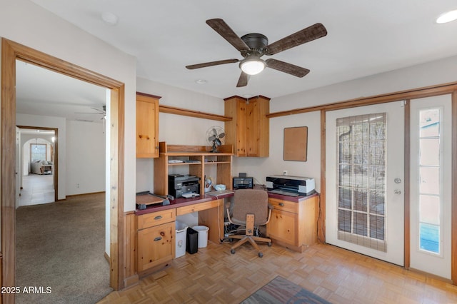 office with light parquet floors and ceiling fan