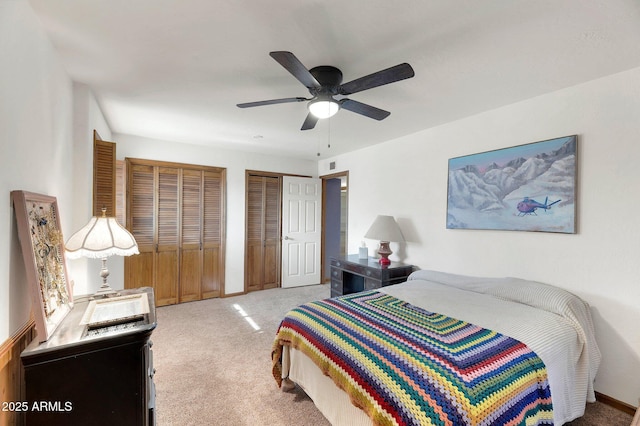 bedroom featuring ceiling fan, carpet, and two closets