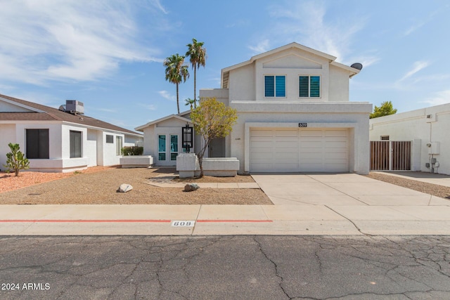 view of front of home with a garage and central AC